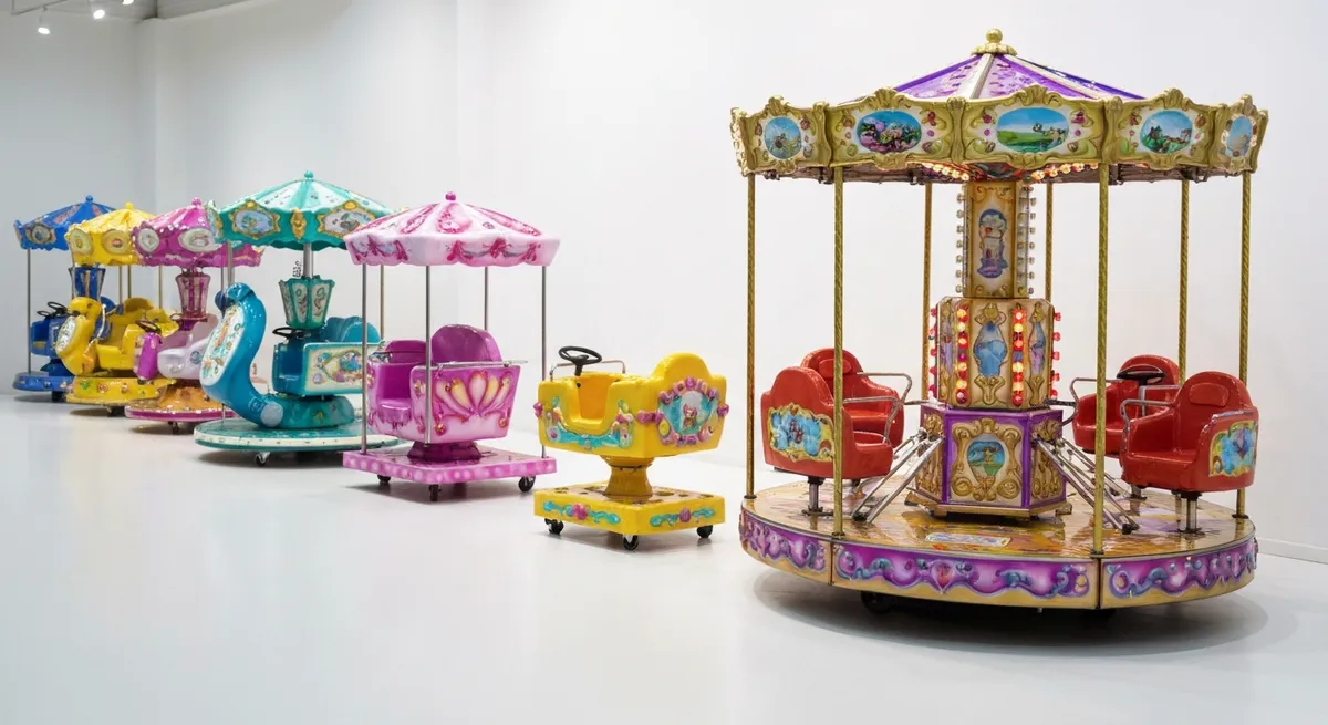 Différents types de manèges automatiques pour enfants exposés en showroom, illustrant les fourchettes de prix selon le modèle